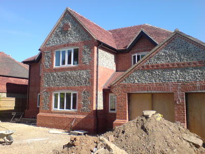 New build house finished in brick and flint to complement the surrounding area